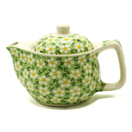A small herbal teapot in light green ceramic with white and yellow daisy patterns for herbal tea cups use