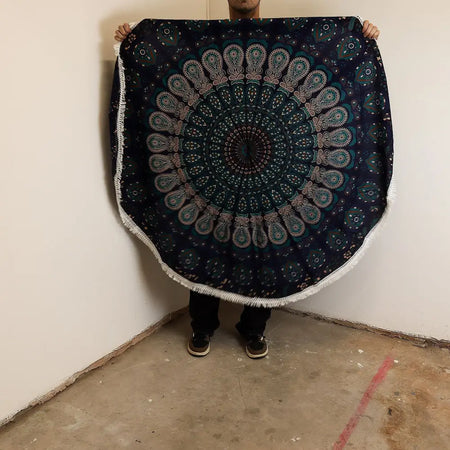 Dark blue circular cotton beach towel with teal and white mandala pattern and fringed edges peacock blues design