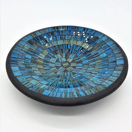 Small mosaic tile dish in blue with gold glitter featuring a circular bowl with blue and black glass tile rings and dark rim