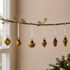 A set of six mouth-blown glass baubles in classic amber with heart star sphere teardrop and acorn shapes hanging on ribbons