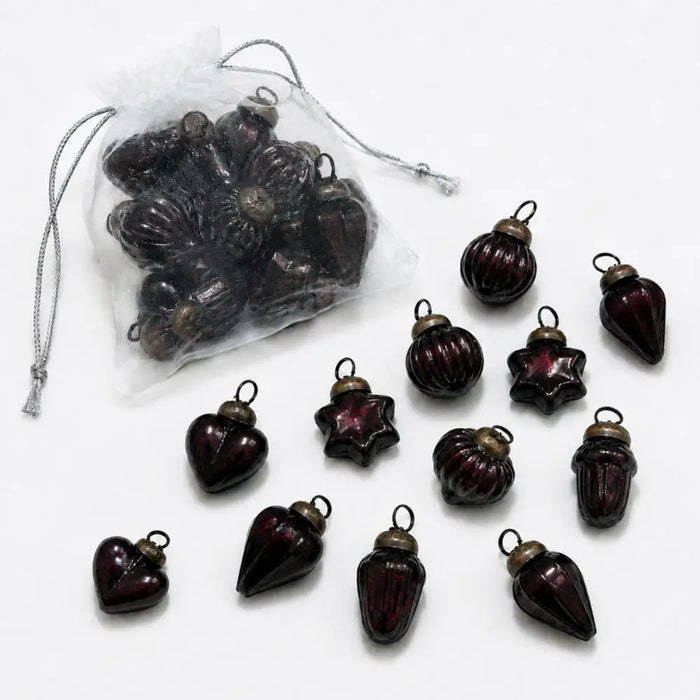 Small mouth-blown glass baubles in dark red with ribbed texture and brass-colored caps for christmas decor