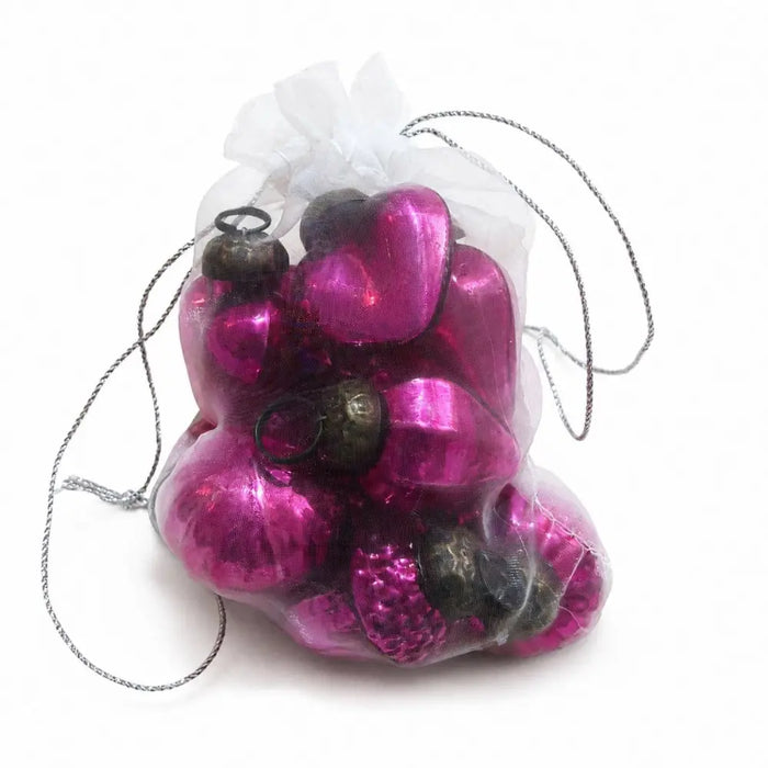 A sheer bag of small mouth-blown glass baubles in classic pink with shiny pink and dark metallic heart shapes
