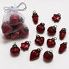 Small mouth-blown glass baubles in classic red with metallic caps shaped like hearts stars and acorns