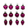 Small mouth-blown glass baubles in vibrant fuschia shaped like hearts stars pumpkins acorns and teardrops with silver caps