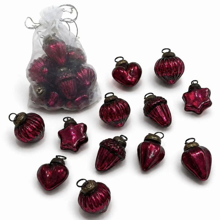 A set of deep red mouth-blown glass baubles shaped like hearts acorns and stars with metallic caps