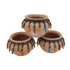 Three natural terracotta plant pots decorated with colorful beaded tassels and woven bands