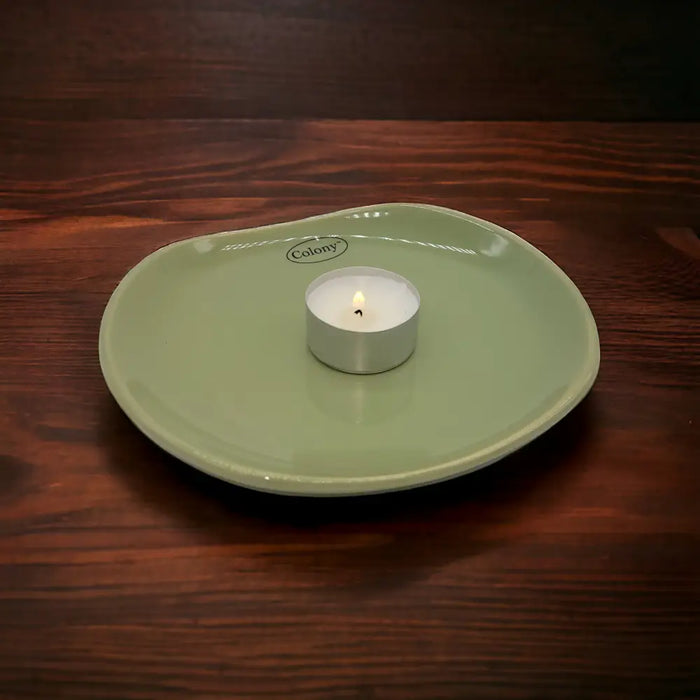 A light green small oval ceramic plate with a glossy finish and colony logo near the edge