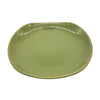 Small oval ceramic plate in sage green with a glossy finish and colony logo near the curved edge