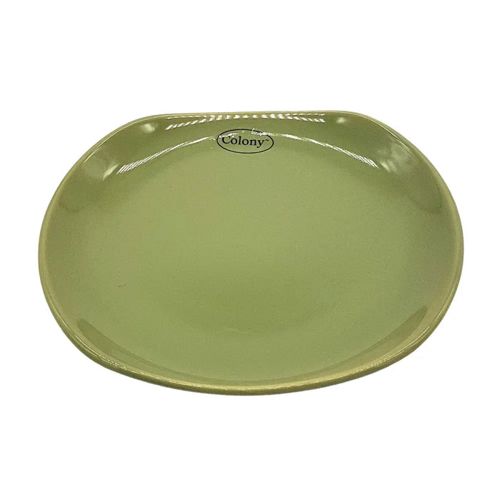Small oval ceramic plate in sage green with a glossy finish and colony logo near the curved edge