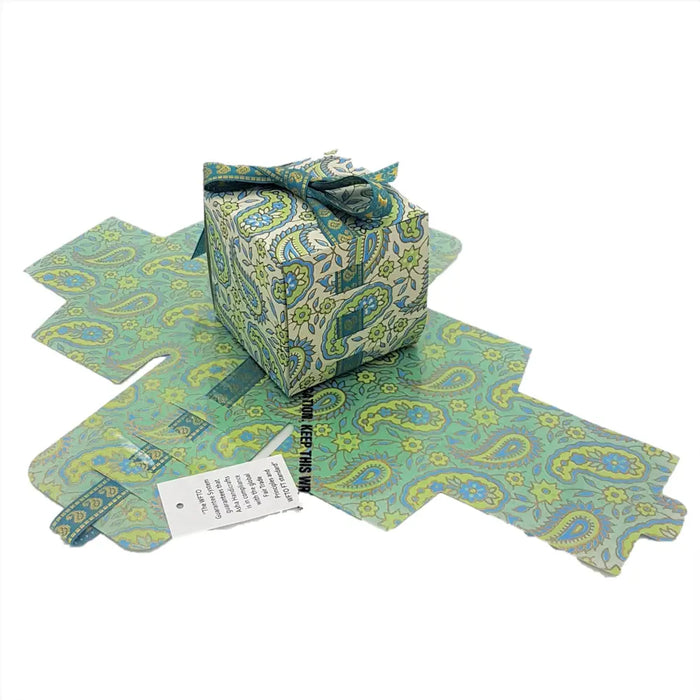 Small printed card gift box wrapped in green and blue paisley paper with matching ribbon bow