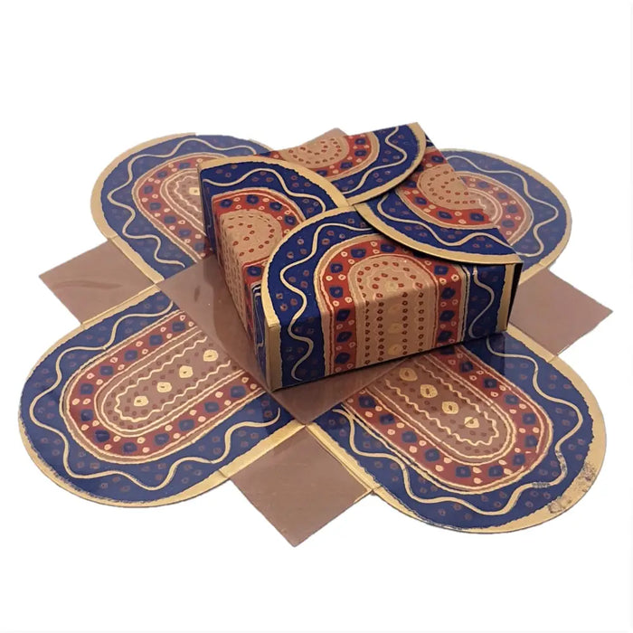 A small printed card gift box with a vibrant blue red and gold origami style patterned design made of paper