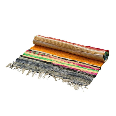 Small rag rug with vibrant rainbow colours in orange red green pink and gray woven with frayed edges