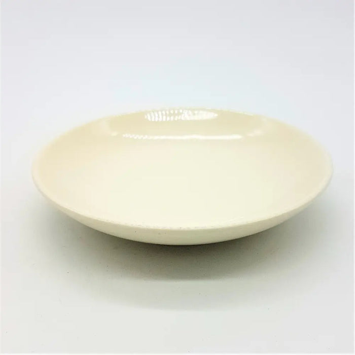 Small round ceramic plate in cream color with a smooth glossy finish and slightly raised rim for serving
