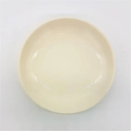 Small round ceramic plate in cream color with glossy finish and raised rim suitable for serving food