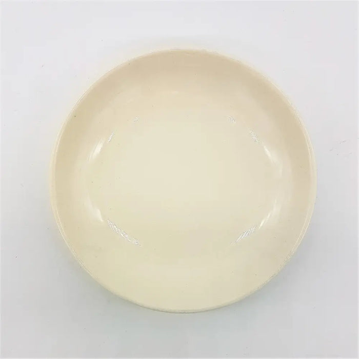 Small round ceramic plate in cream color with glossy finish and raised rim suitable for serving food