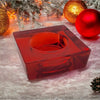 A translucent red square glass tealight holder with a circular indentation for holding a small tealight candle