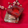 Small square glass tealight holder in red translucent glass with frosted texture and square design