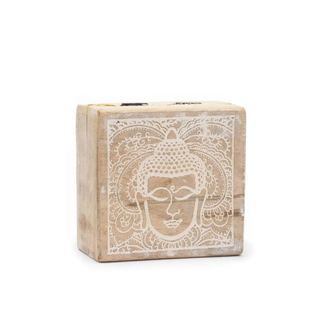 A small square wooden box with a weathered finish and a white carved buddha face design on the lid