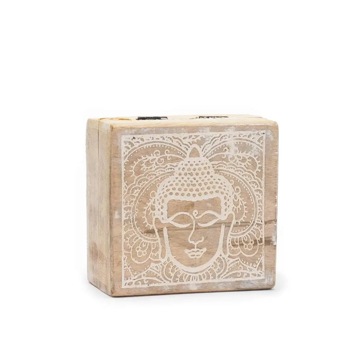 A small square wooden box with a weathered finish and a white carved buddha face design on the lid