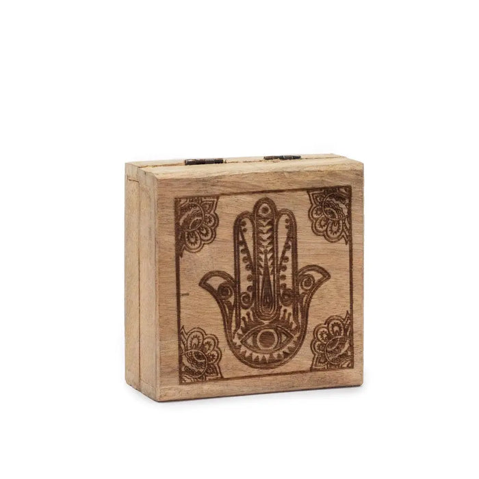 A small square wooden box with a dark brown hamsa hand design engraved on the front