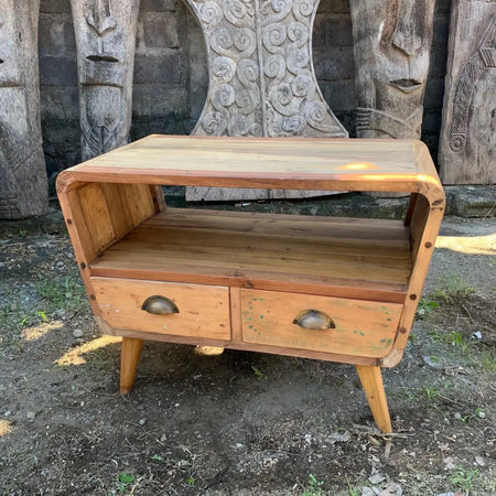 A small tv stand with two drawers made of recycled wood in warm natural finish and curved legs
