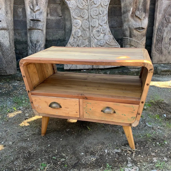 A small tv stand with two drawers made of recycled wood in warm natural finish and curved legs
