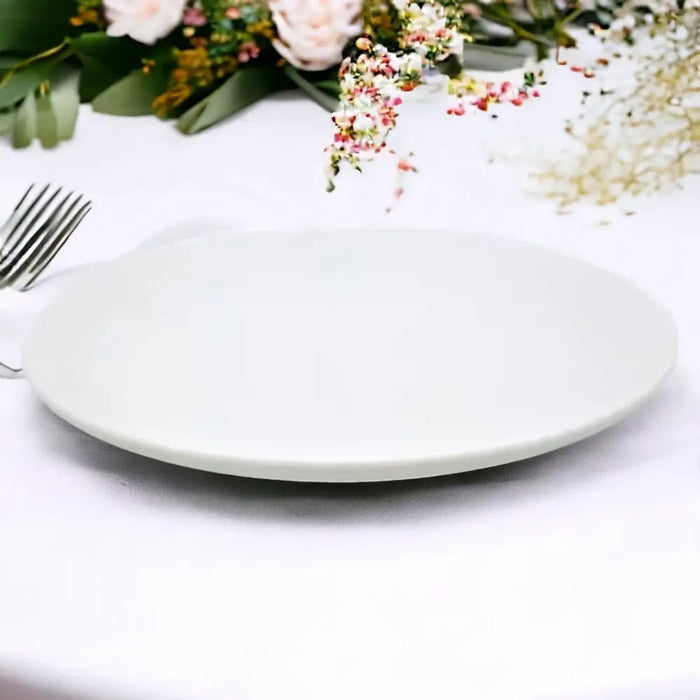 A small white porcelain plate with a smooth glossy finish and subtle swirl pattern on a minimalist design