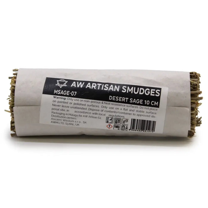 A roll of dried desert sage smudge stick wrapped in white paper with a black aw artisan smudges label