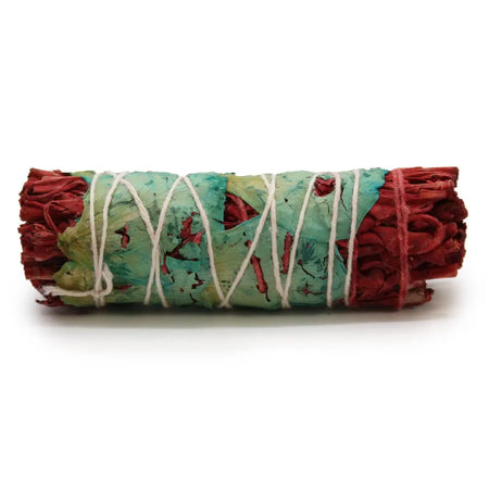 A rolled 10cm smudge stick of dried blood floral sage tied with white string and wrapped in green and teal leaves