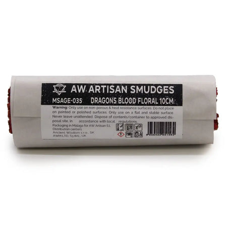 A cylindrical smudge stick of blood floral sage wrapped in white paper with black label showing healing properties
