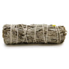 A smudge stick of white sage and blue sage leaves tied with natural twine and a small yellow tag on one end