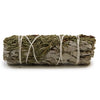 A smudge stick of white sage and juniper tied with white twine showing green and grayish-white dried leaves