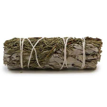 A smudge stick of white sage and juniper tied with white twine showing green and grayish-white dried leaves