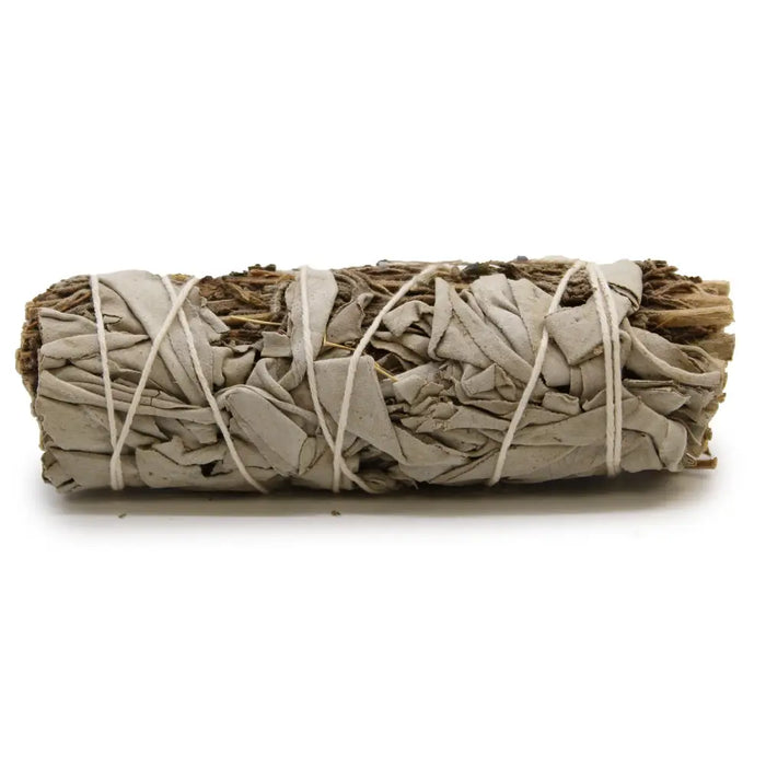 A smudge stick of white sage and lavender tied with white twine showing dried green and purple leaves