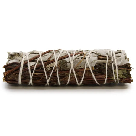 A smudge stick of white sage and peppermint with silvery gray leaves and brown stems tied with white twine
