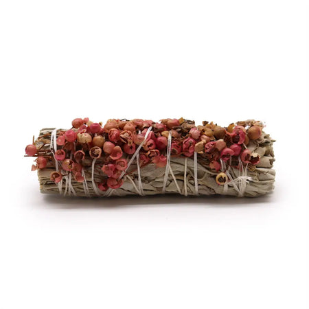 A smudge stick of white sage tied with white string and pink pirul seed for purifying properties measuring 10cm