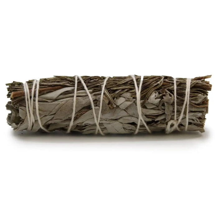 A smudge stick made of white sage and rosemary tied with natural twine showing dried green leaves bundle