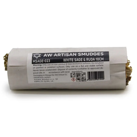 A cylindrical smudge stick of white sage and ruda wrapped in light gray paper with a black label to clear negative energy