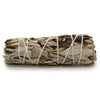 A smudge stick of dried white sage and yerba santa tied with natural twine showing gray, beige, and purple leaves