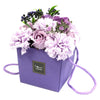 Purple soap flowers arranged as a handcrafted bouquet of lavender rose and carnation in a lavender box with strap