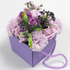 Purple soap flowers arranged with lavender rose and carnation in a matching lavender box with fabric handle