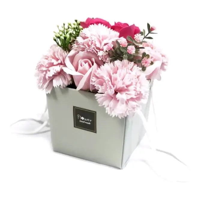 A soap flowers bouquet featuring pink rose and red carnations in a silver-gray gift box with white ribbon ties