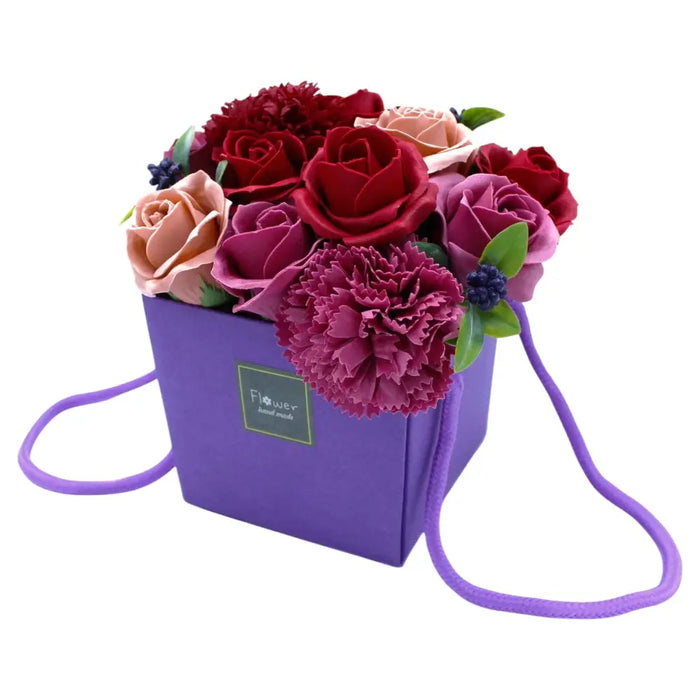 Purple square box with handle filled with red pink and mauve soap flowers in a soap flower bouquet purple flower garden