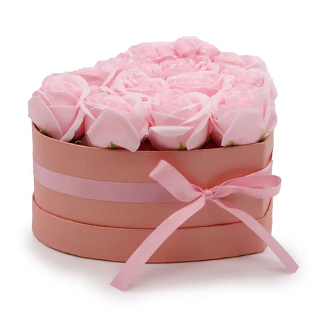A heart-shaped box filled with soft pink soap flowers shaped like roses tied with a matching satin ribbon