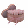 A blush pink heart-shaped box with matching ribbon filled with pastel pink soap flowers roses
