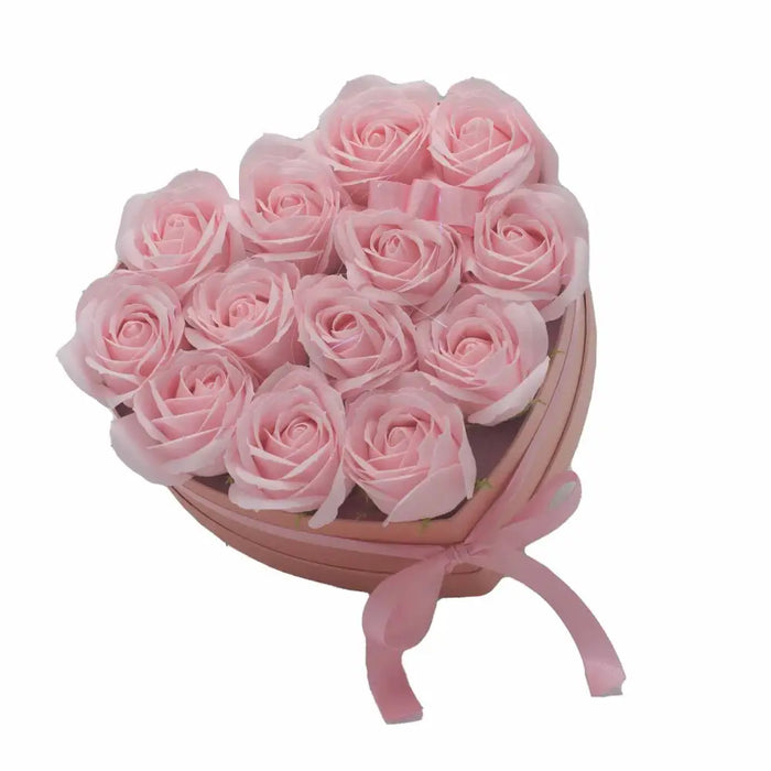 A heart-shaped box filled with pink soap flowers tied with a matching satin ribbon in a rose heart gift bouquet