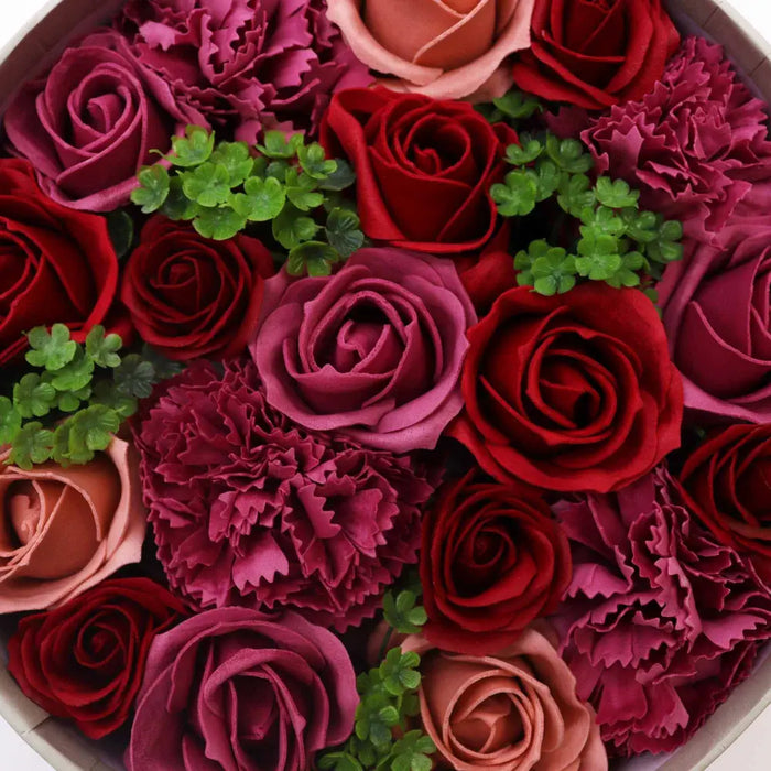 A soap flower gift box with vintage red roses handcrafted from soap in deep reds burgundies and soft pinks with green leaves
