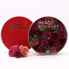 A round red-lidded flower gift box with dense artificial soap flower gift vintage red roses in burgundy pink hues