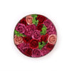 A circular soap flower gift box with vintage red roses and carnations in deep red magenta and blush pink with green foliage