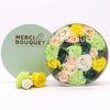 A round light green flower gift box with colorful soap flowers in yellow pink white and green for spring celebrations
